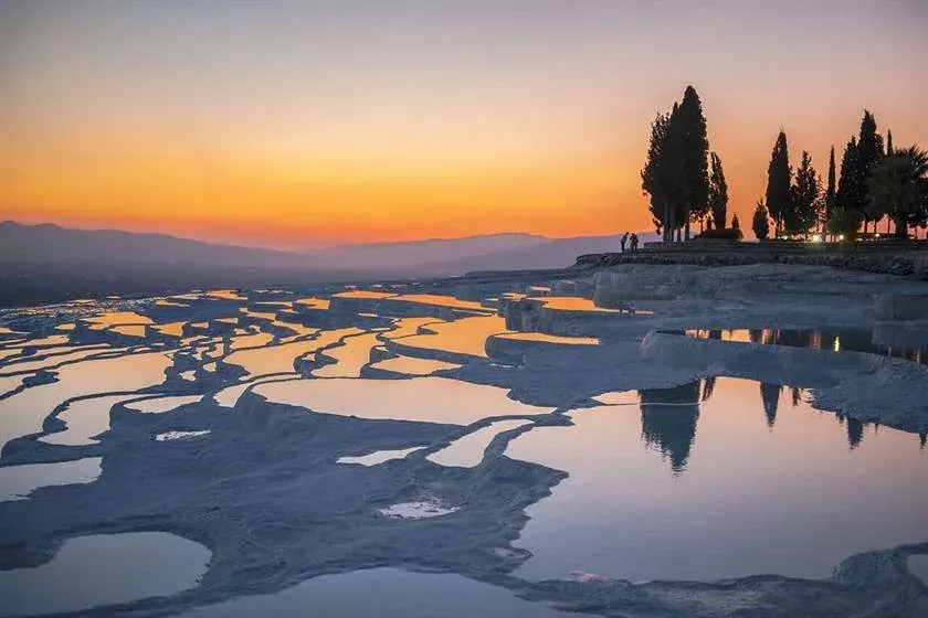 Sunset over the white travertine terraces at Pamukkale